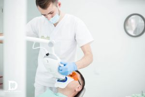 Il medico esegue lo sbiancamento dei denti con una lampada Philips ZOOM White Speed