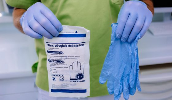 Per gli interventi chirurgici usiamo i guanti sterili (confezionati) Il dentista moldavo mostra la differenza tra guanti sterili e guanti monouso