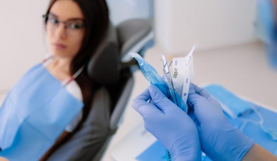 Tutti gli strumenti dentali sono sterilizzati e aperti di fronte al paziente. L’assistente alla poltrona nella nostra clinica di Chisinău apre gli strumenti sterilizzati di fronte al paziente.